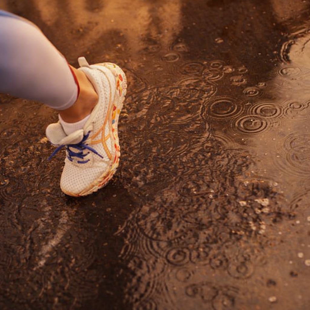 Pernas de maratonista cansadas a correr no asfalto, mostrando impacto no tornozelo